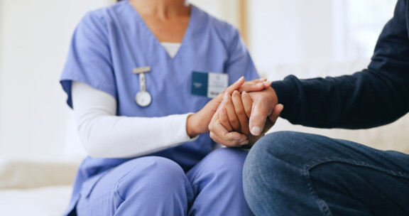 Nurse, patient and holding hands closeup for diagnosis news, consultation or test result support. Medical worker, person and fingers touch for anxiety stress or empathy wellness, report or exam hope